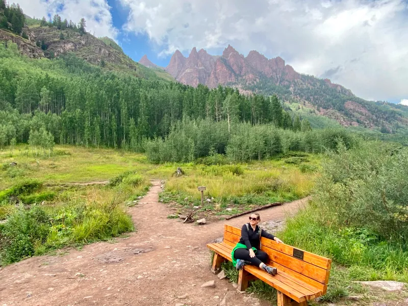 Emily Backes sitting on a bench near Maroon Bells, Colorado