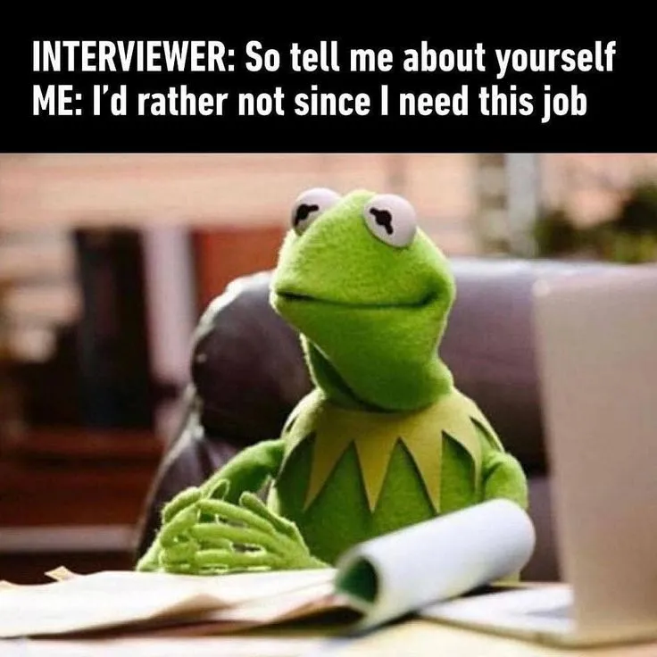 Kermit the Frog sitting at a desk with papers and a laptop, captioned "Interviewer: So tell me about yourself. Me: I'd rather not since I need this job."
